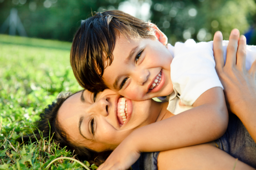 Mother and young son laying on grass